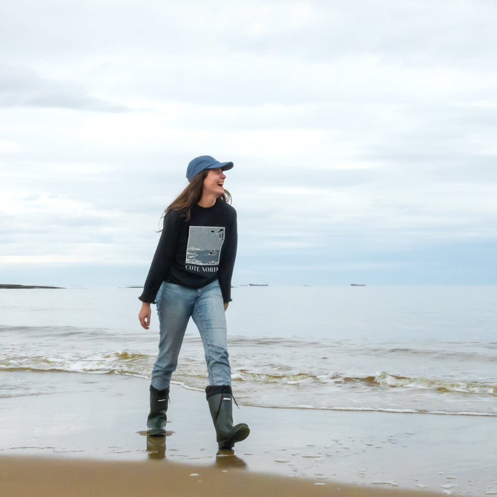 Fille riant sur la berge d'une plage de Port-Cartier